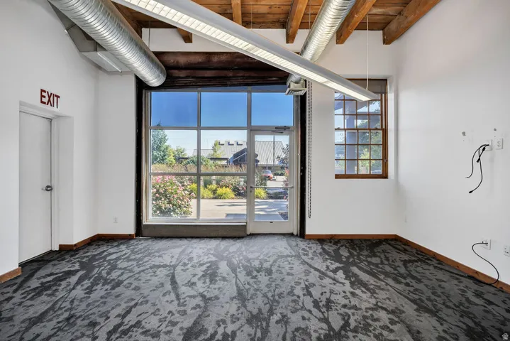Expansive commercial space featuring a prominent glass garage door and an additional multi-pane window