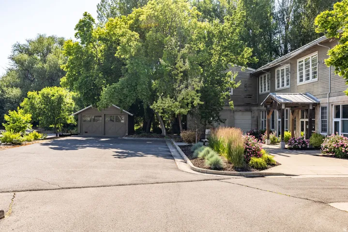 Expansive paved driveway leading to a two-story residence with a covered entry