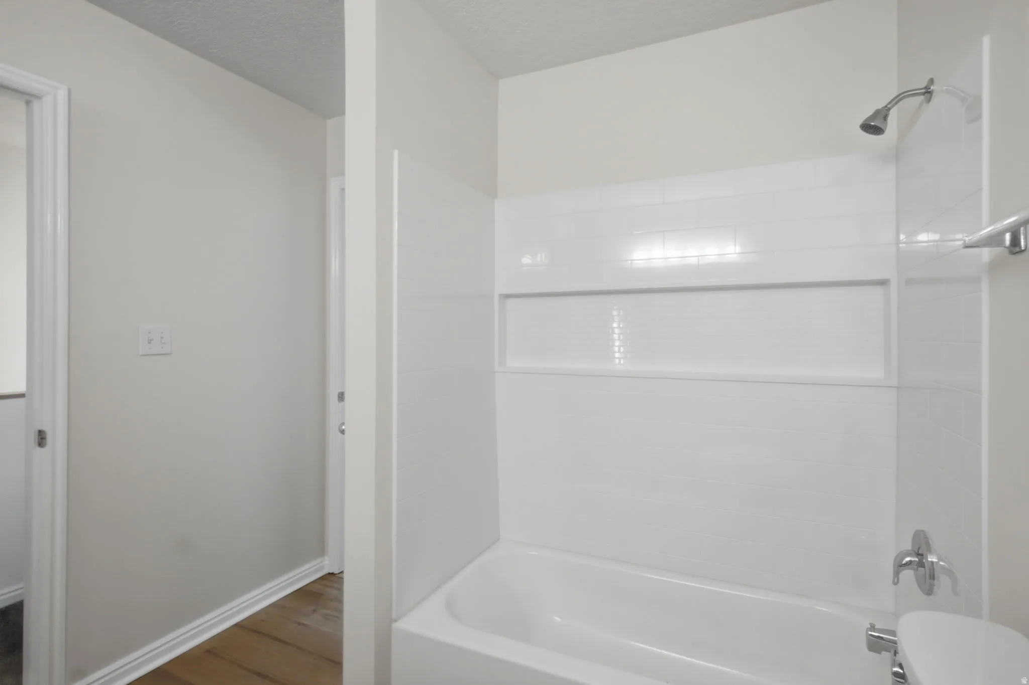 White subway tile surround with recessed niche and chrome fixtures