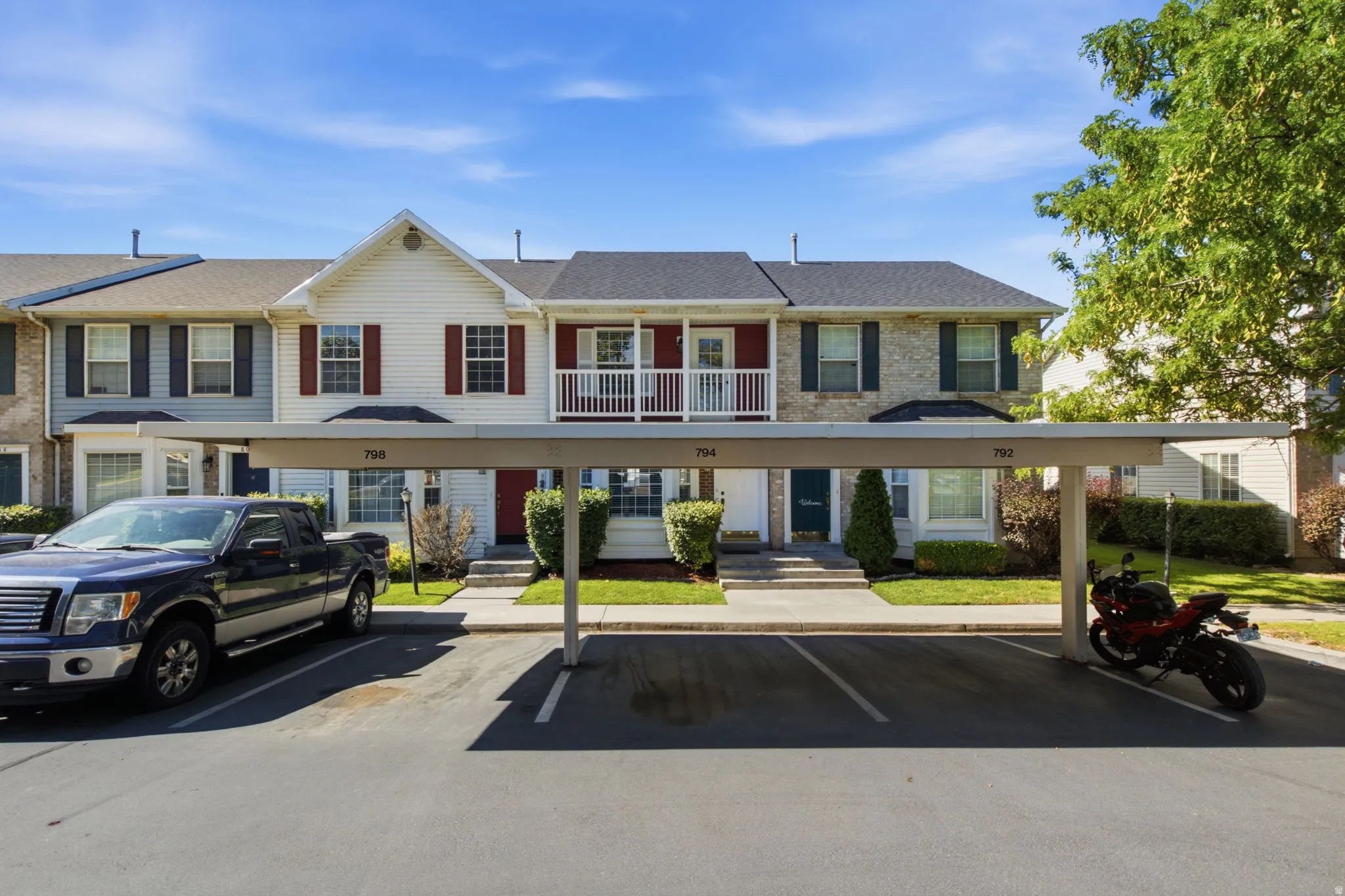 Multi-level townhome featuring a carport with designated parking