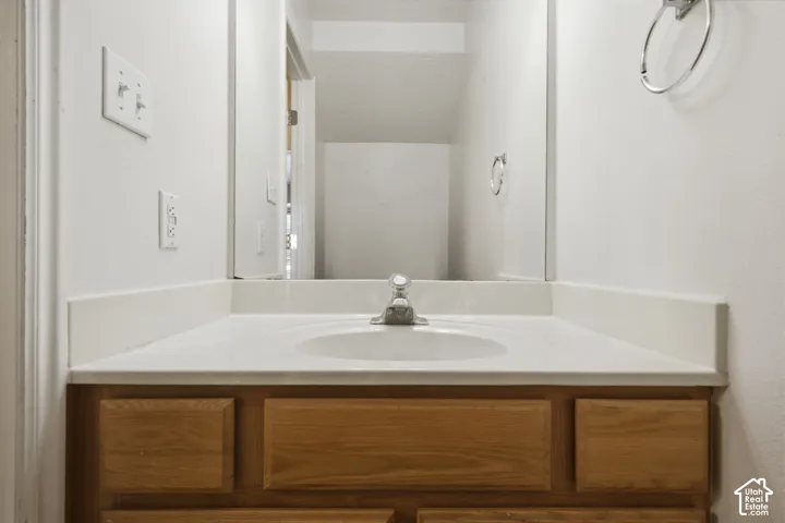 Bathroom vanity featuring an integrated sink, laminate countertop, and wood-finish cabinetry