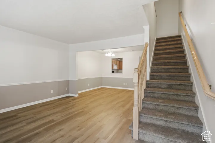 Living area featuring wood-finish flooring, two-tone wall paint, and white baseboards