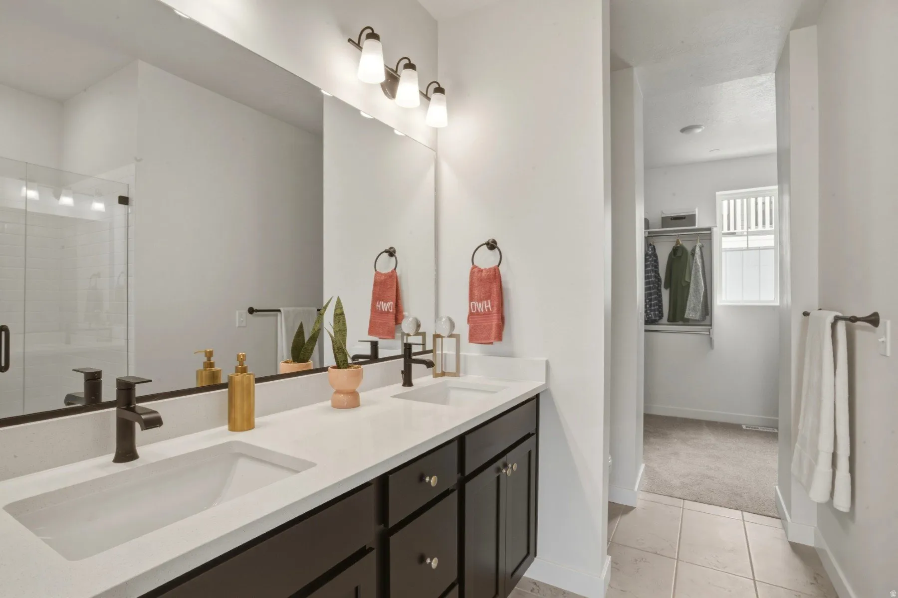 Double vanity with integrated white sinks, quartz-finish countertop, and dark bronze-finish fixtures