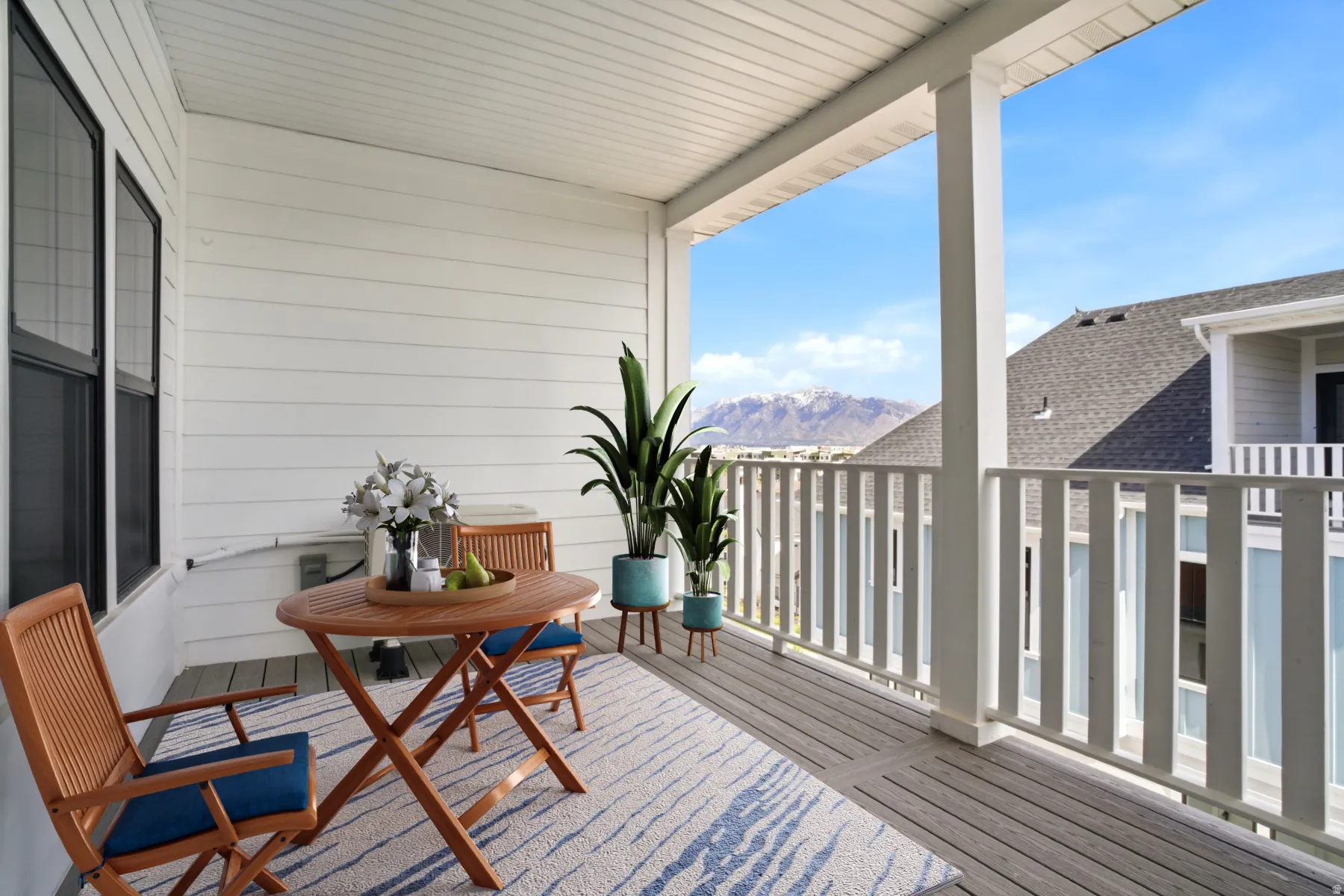 Covered balcony featuring wood-finish flooring and white siding