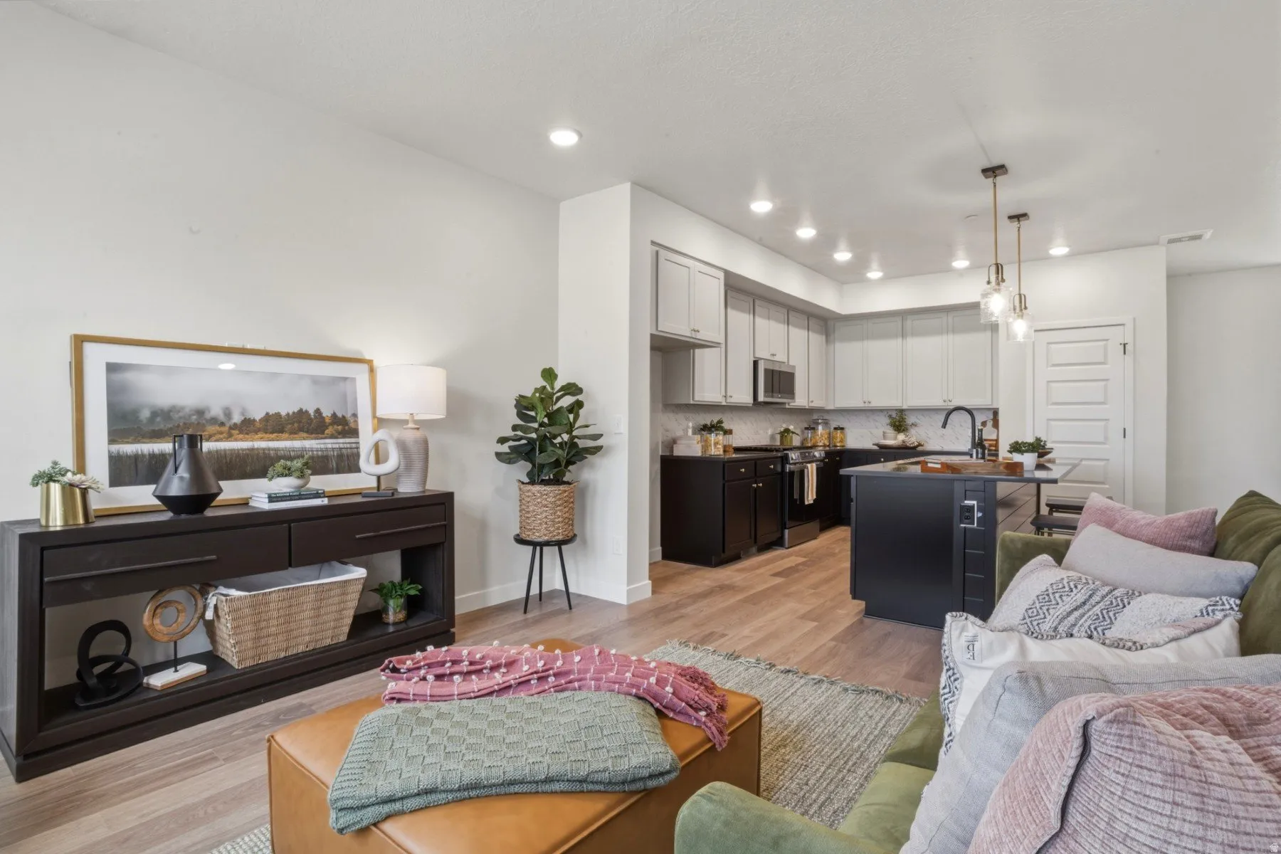 Open-concept living space featuring wood-finish flooring, recessed lighting, and a modern kitchen