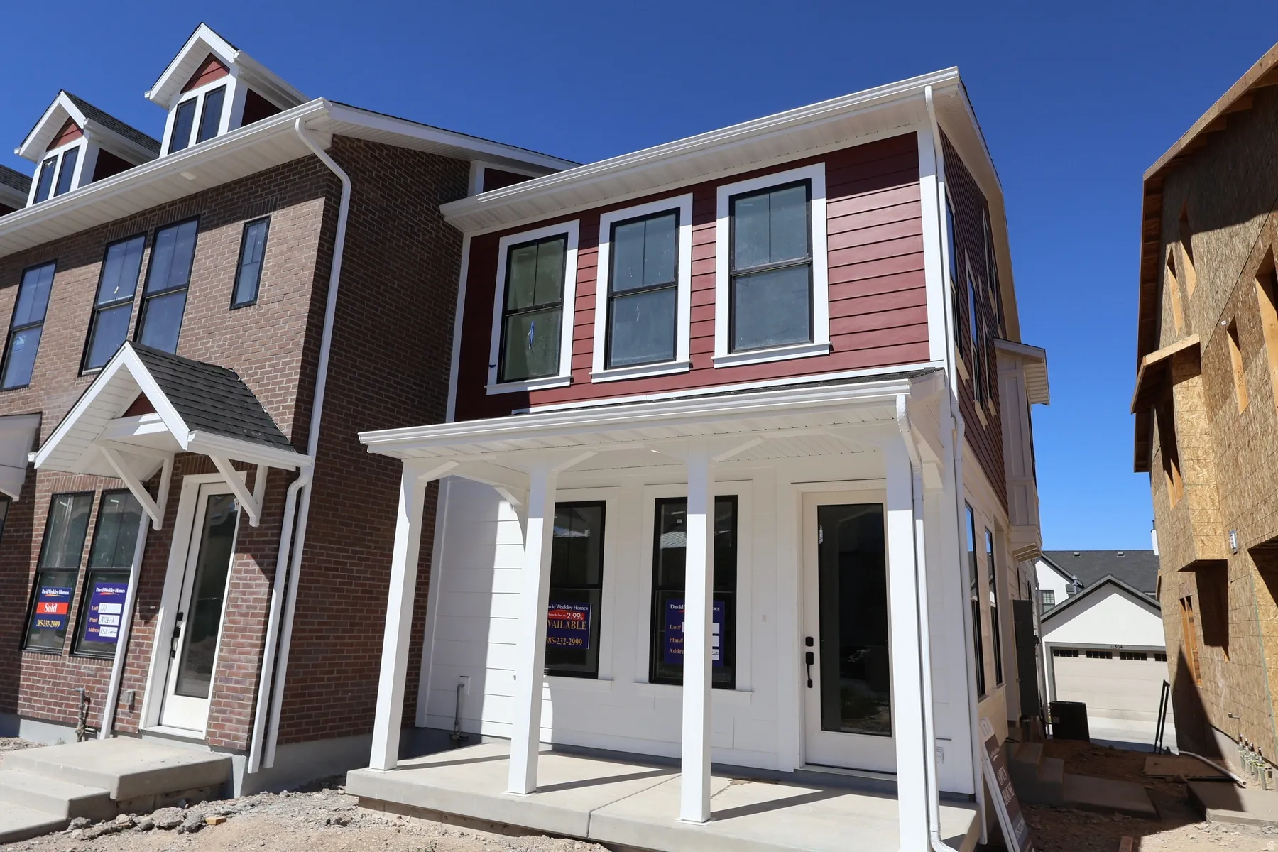 Red siding exterior with white trim and a covered front porch featuring four white columns