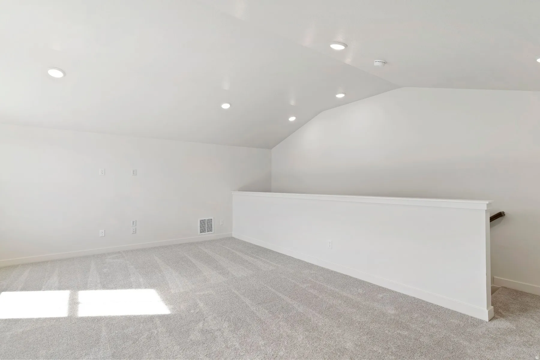 Spacious bonus room featuring vaulted ceilings, recessed lighting, neutral carpeting, and a white interior railing
