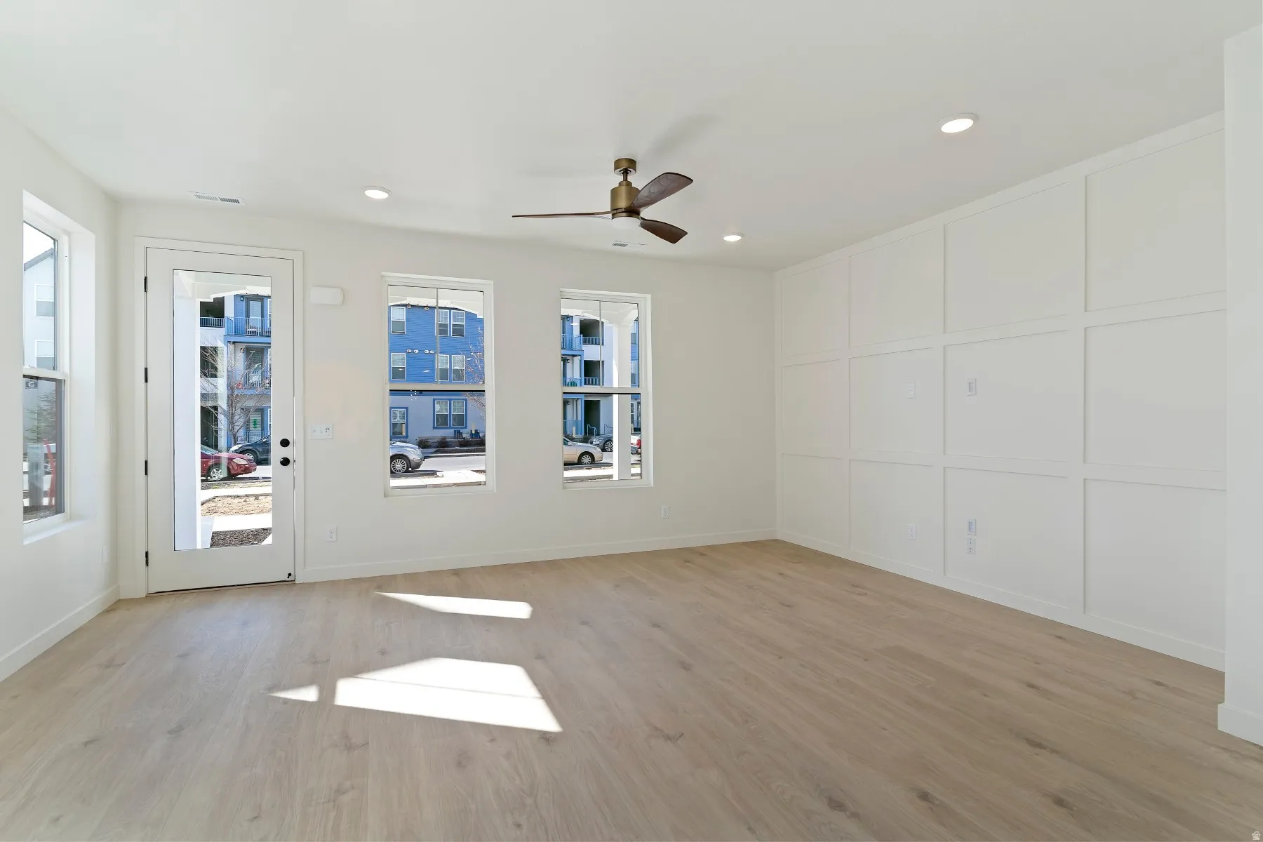 Open-concept living area featuring light wood-finish flooring, a contemporary ceiling fan, and recessed lighting