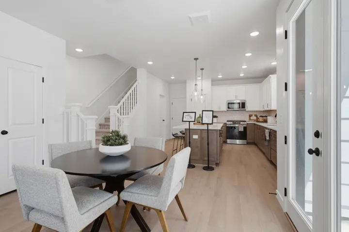 Modern kitchen with stainless steel appliances, two-tone cabinetry, and an island with pendant lighting