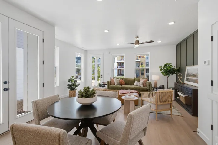 Open-concept living area with wood-finish flooring, a contemporary ceiling fan, and recessed lighting