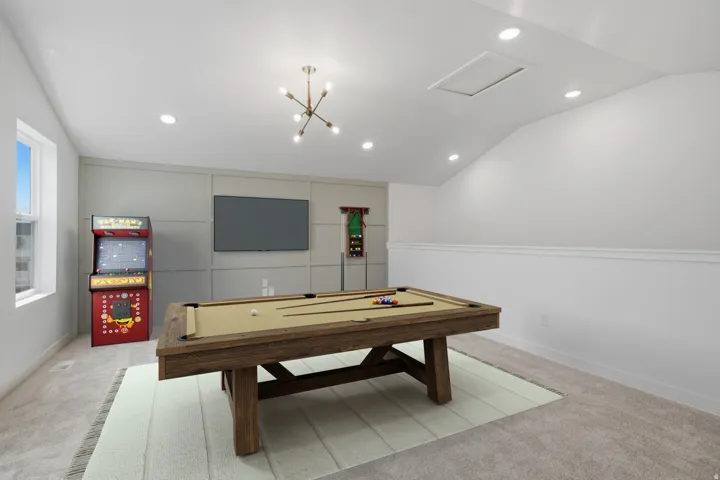 Spacious bonus room featuring an angled ceiling, recessed lighting, and a window