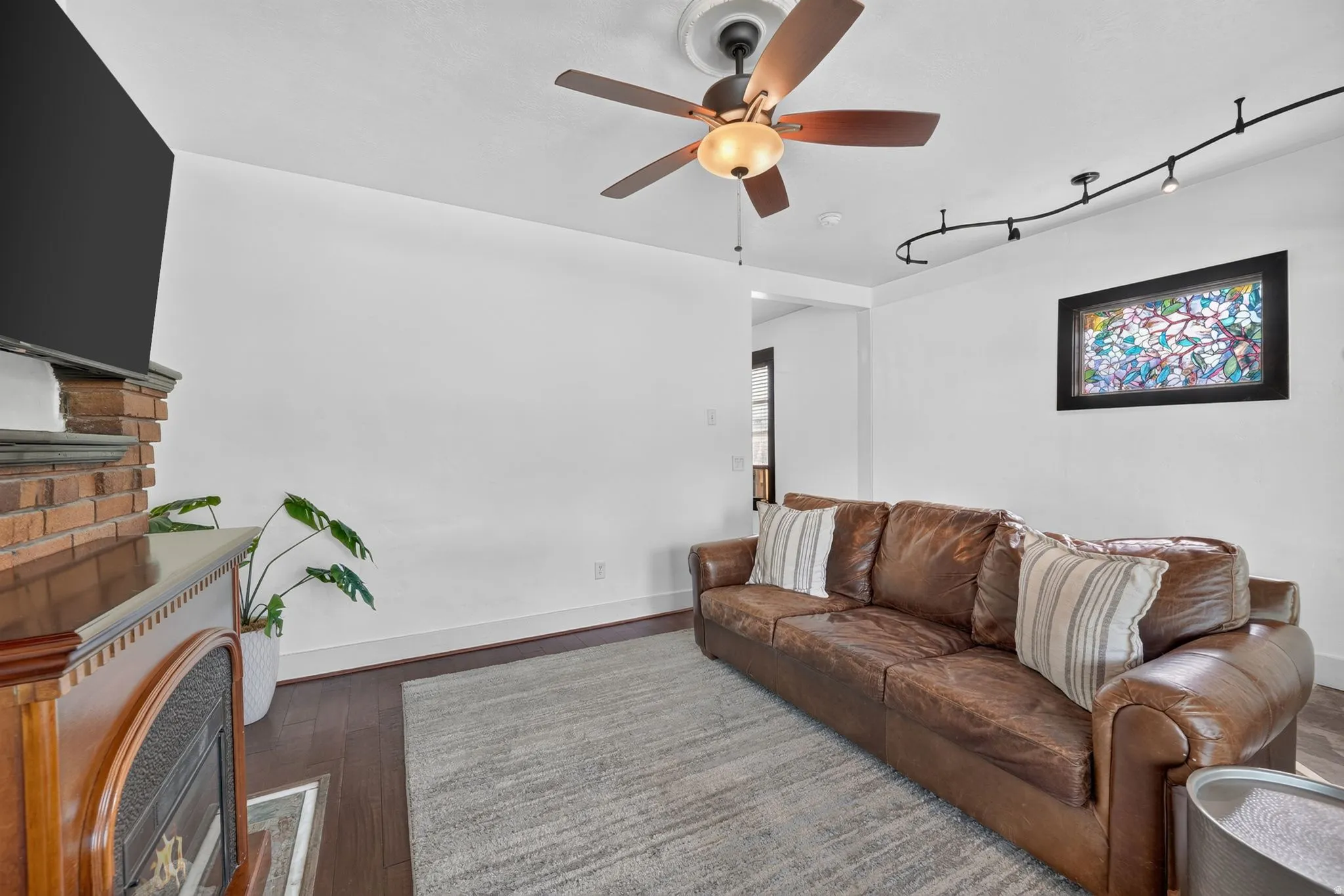 Living area featuring dark laminate flooring and a light-toned area rug
