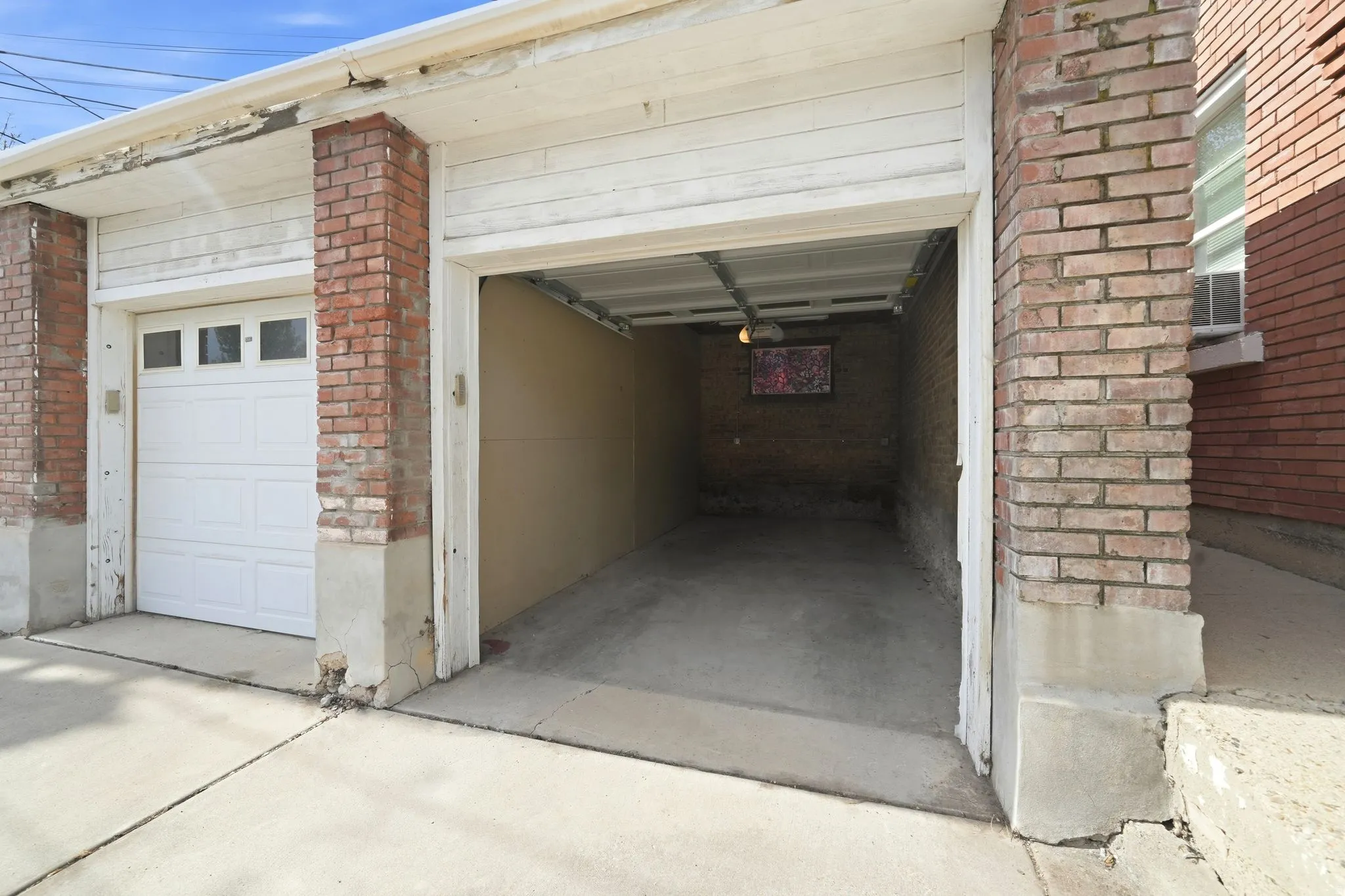 Two-car garage structure featuring brick columns and white paneled doors