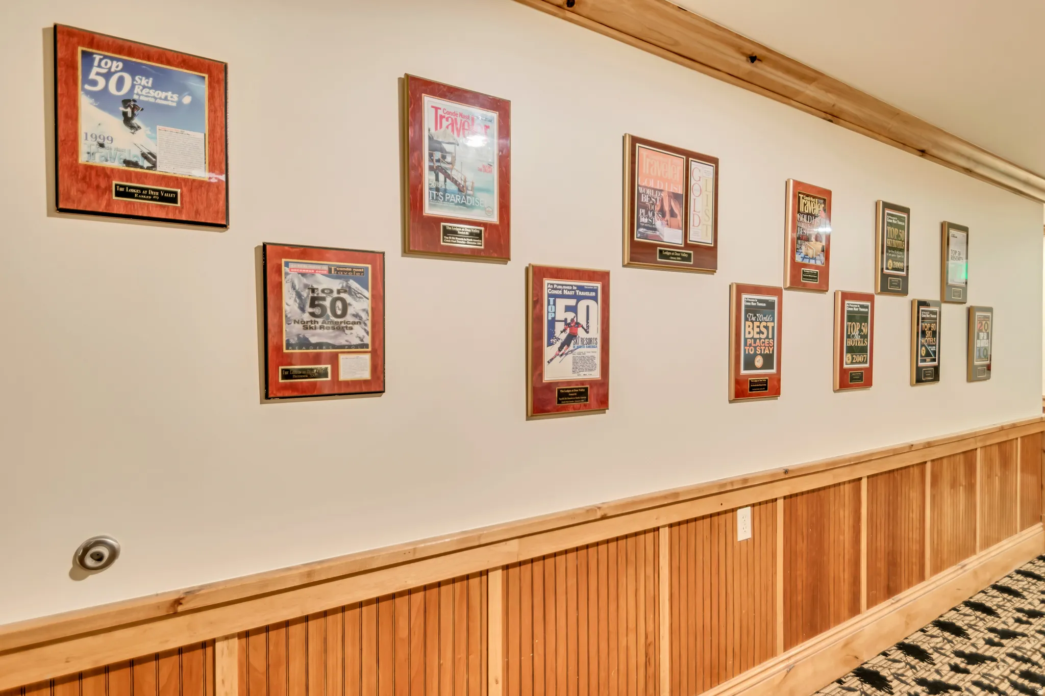 Hallway featuring natural wood wainscoting with horizontal trim, a light-toned wall, and recessed lighting