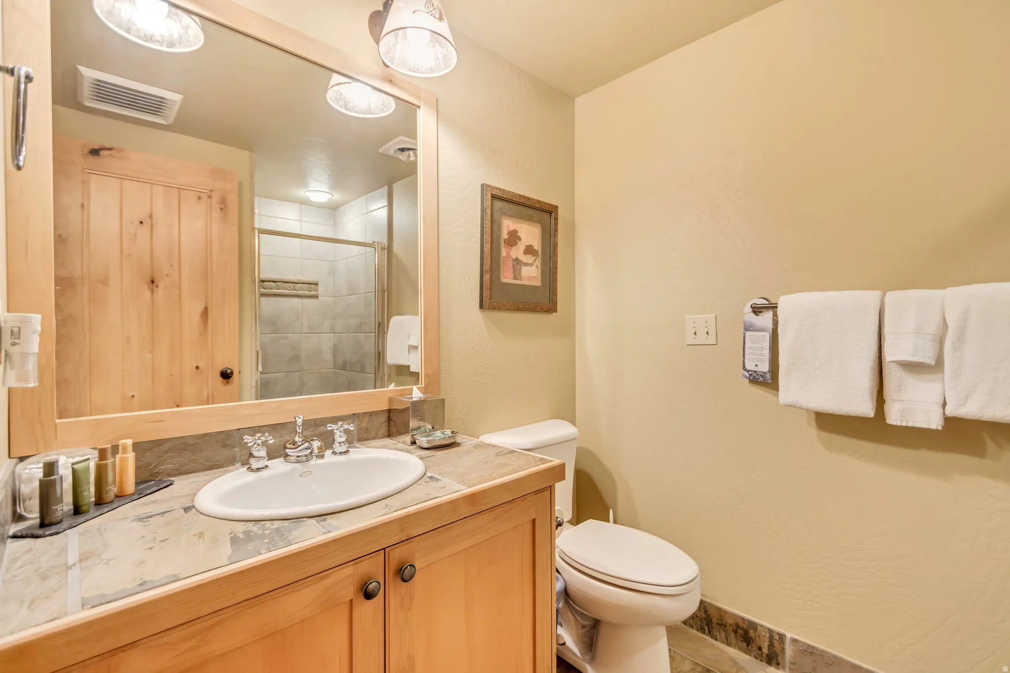 Bathroom vanity with a surface-mount sink, chrome faucet, and stone-look countertop