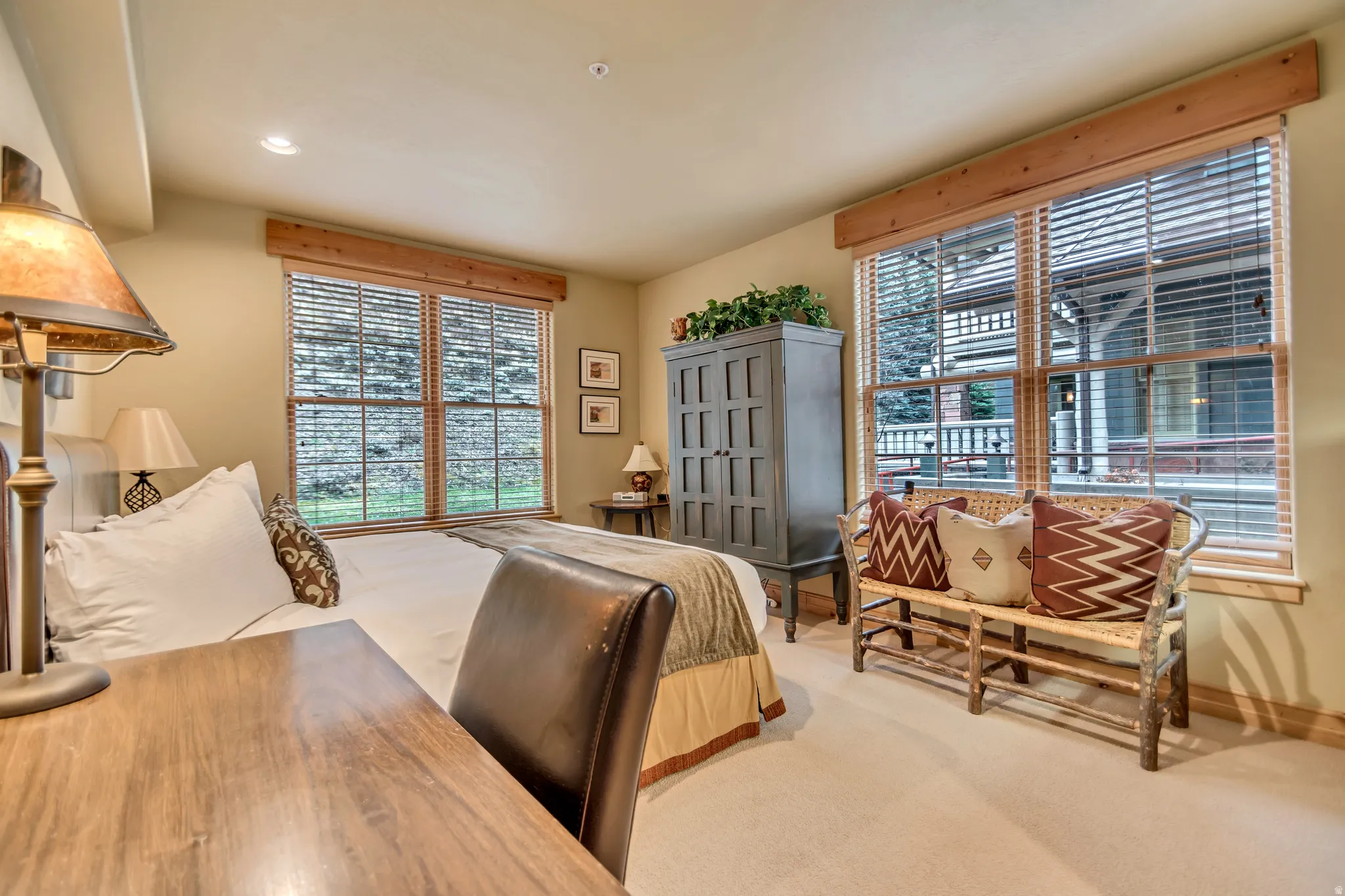 Bedroom featuring two large windows with blinds, light wood trim, recessed lighting, and neutral carpeting