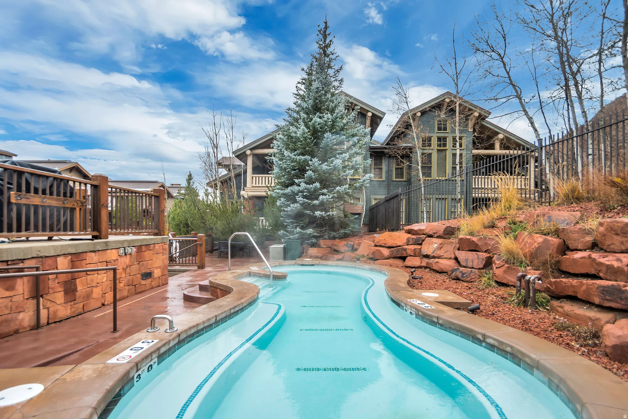 Curved outdoor pool with integrated steps and stainless steel handrails