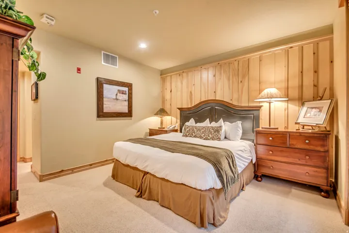 Carpeted bedroom with wood paneling accent wall, recessed lighting, and crown molding