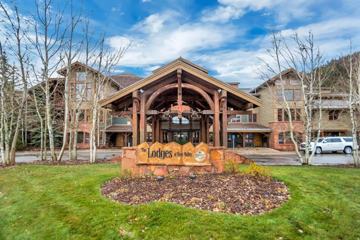 Mountain-style building featuring a prominent timber-frame porte-cochère entrance