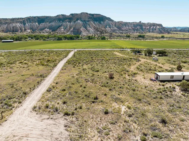 Expansive rural property featuring a dirt access road, diverse scrubland
