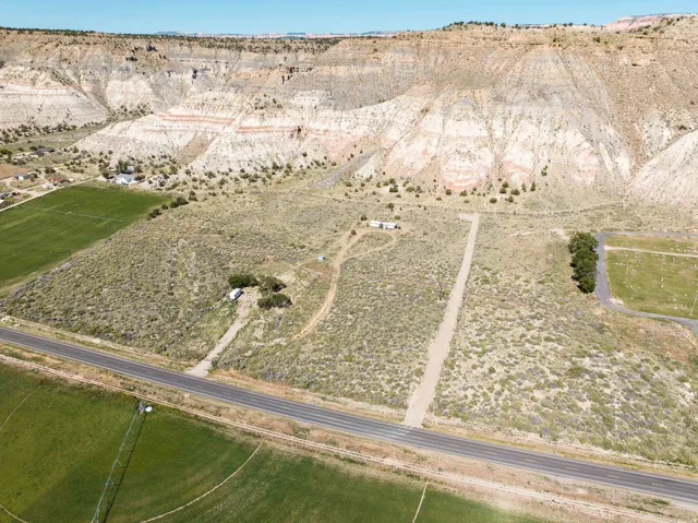 Expansive acreage featuring a paved road frontage, natural desert landscaping, and a distant mountain backdrop
