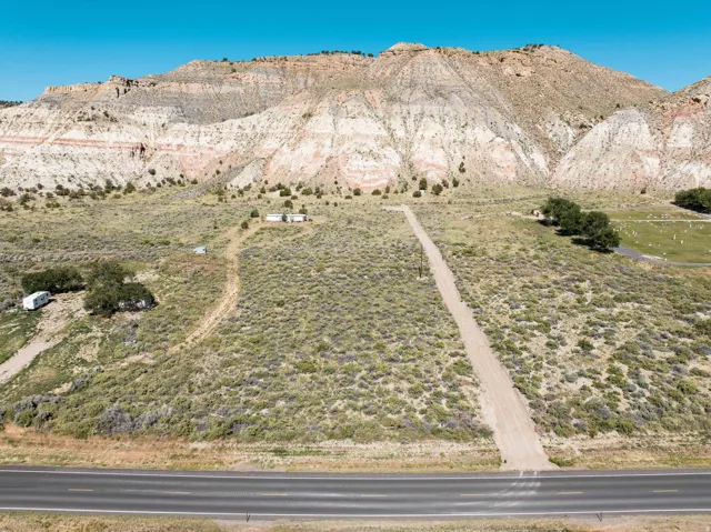 Expansive acreage featuring a broad, unpaved driveway ascending towards the horizon