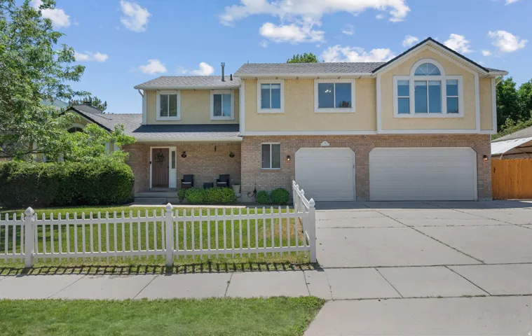 Two-story residence featuring a brick and stucco facade, a three-car garage