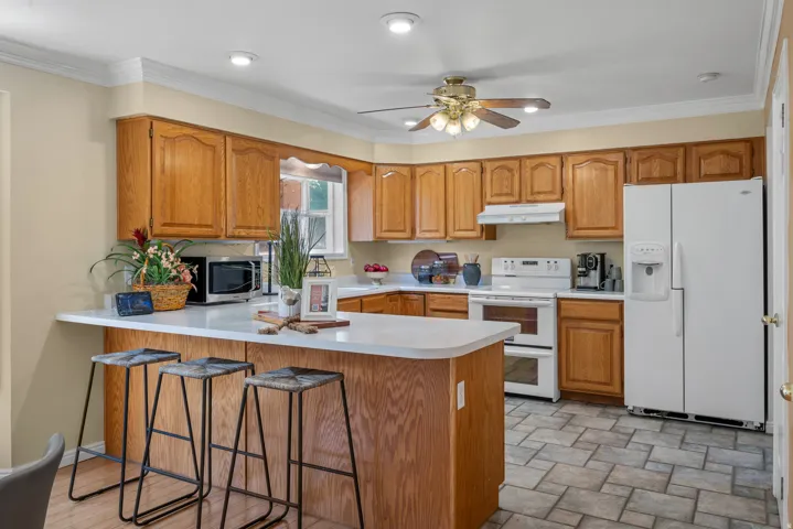 Kitchen featuring wood-finish cabinetry, white countertops, and tile flooring