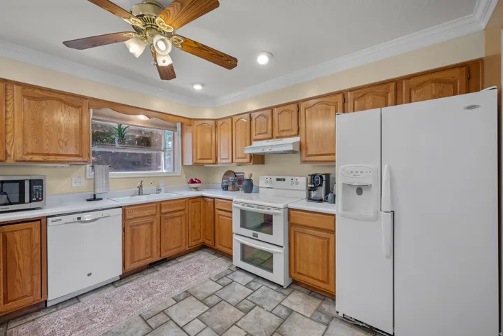 Kitchen featuring wood cabinetry, white appliances, recessed lighting and tiled flooring