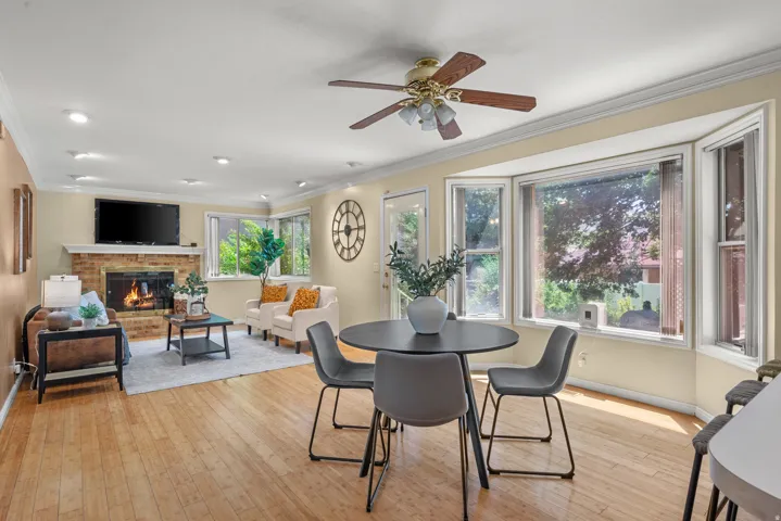 Living area featuring wood-finish flooring, a brick fireplace with a white mantel, recessed lighting, and a ceiling fan