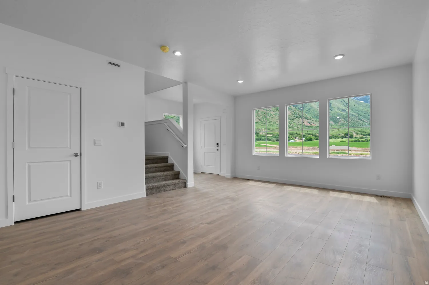 Spacious interior featuring wood-finish flooring, recessed lighting, and white trim throughout
