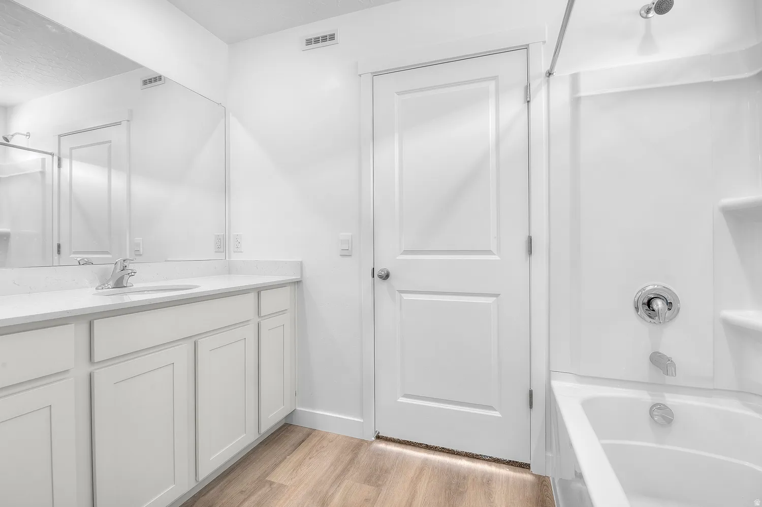 Full bathroom with a white vanity featuring a light-colored countertop and integrated sink