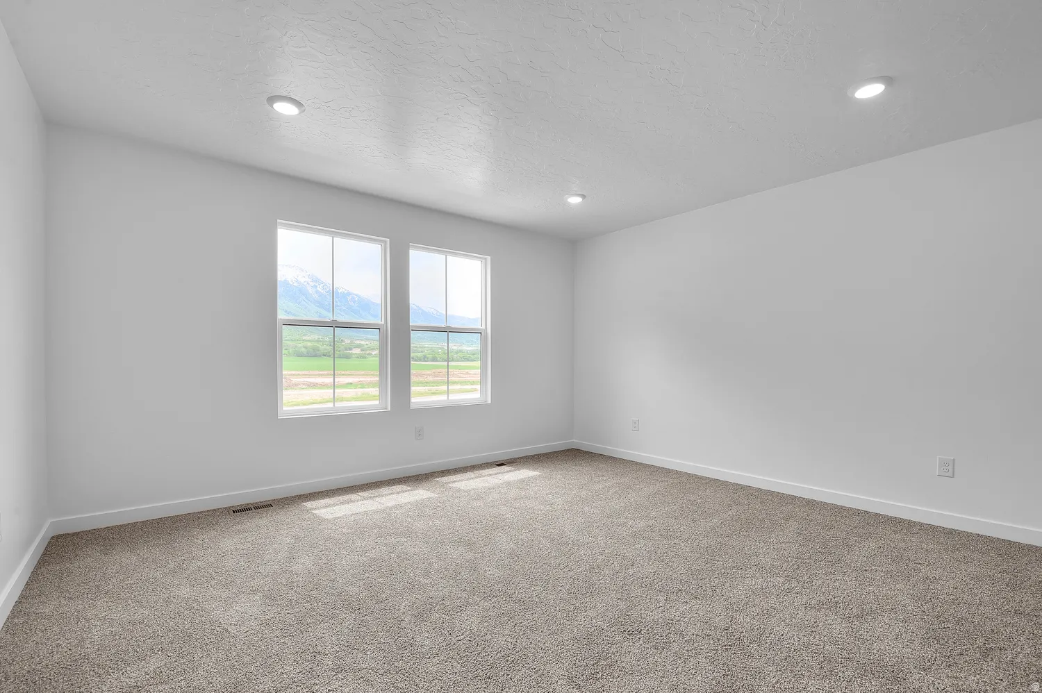 Spacious room featuring neutral carpeting and white walls