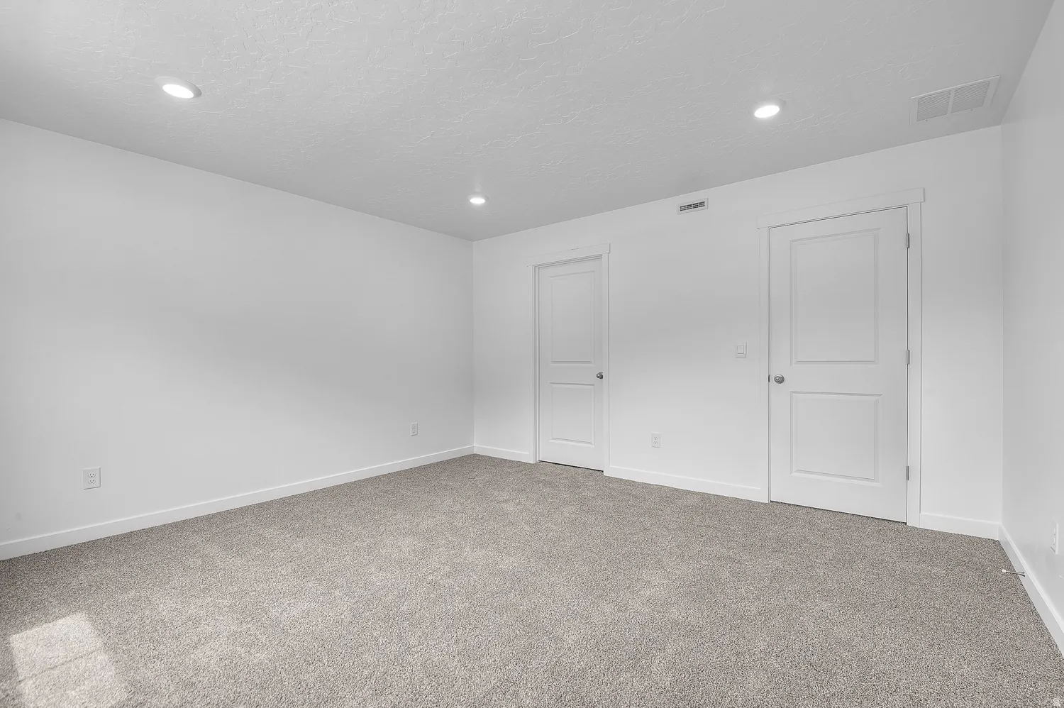 Spacious room featuring neutral carpet flooring, recessed lighting, and crisp white walls