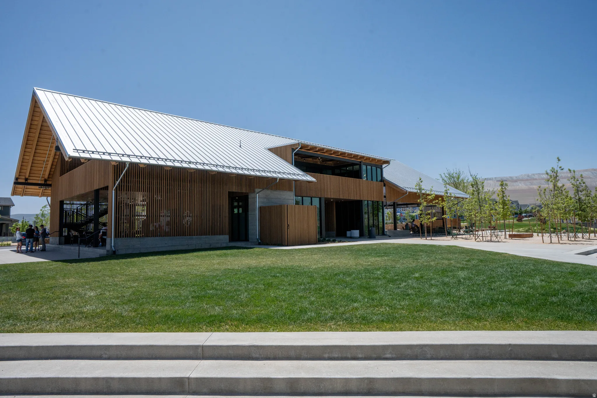 Modern architectural design featuring a prominent metal roof and wood-finish siding
