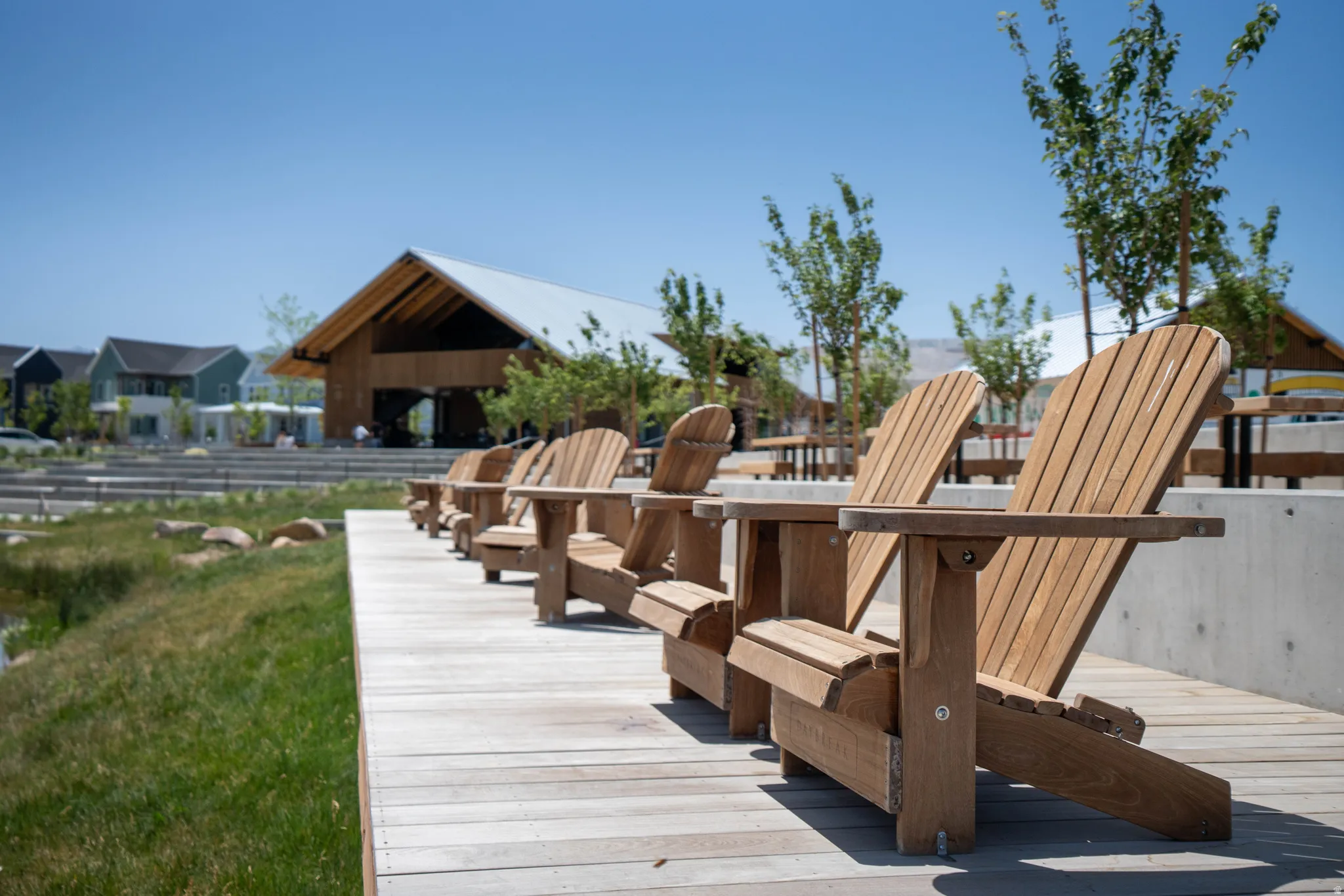 Outdoor seating area with a wooden deck and multiple Adirondack chairs