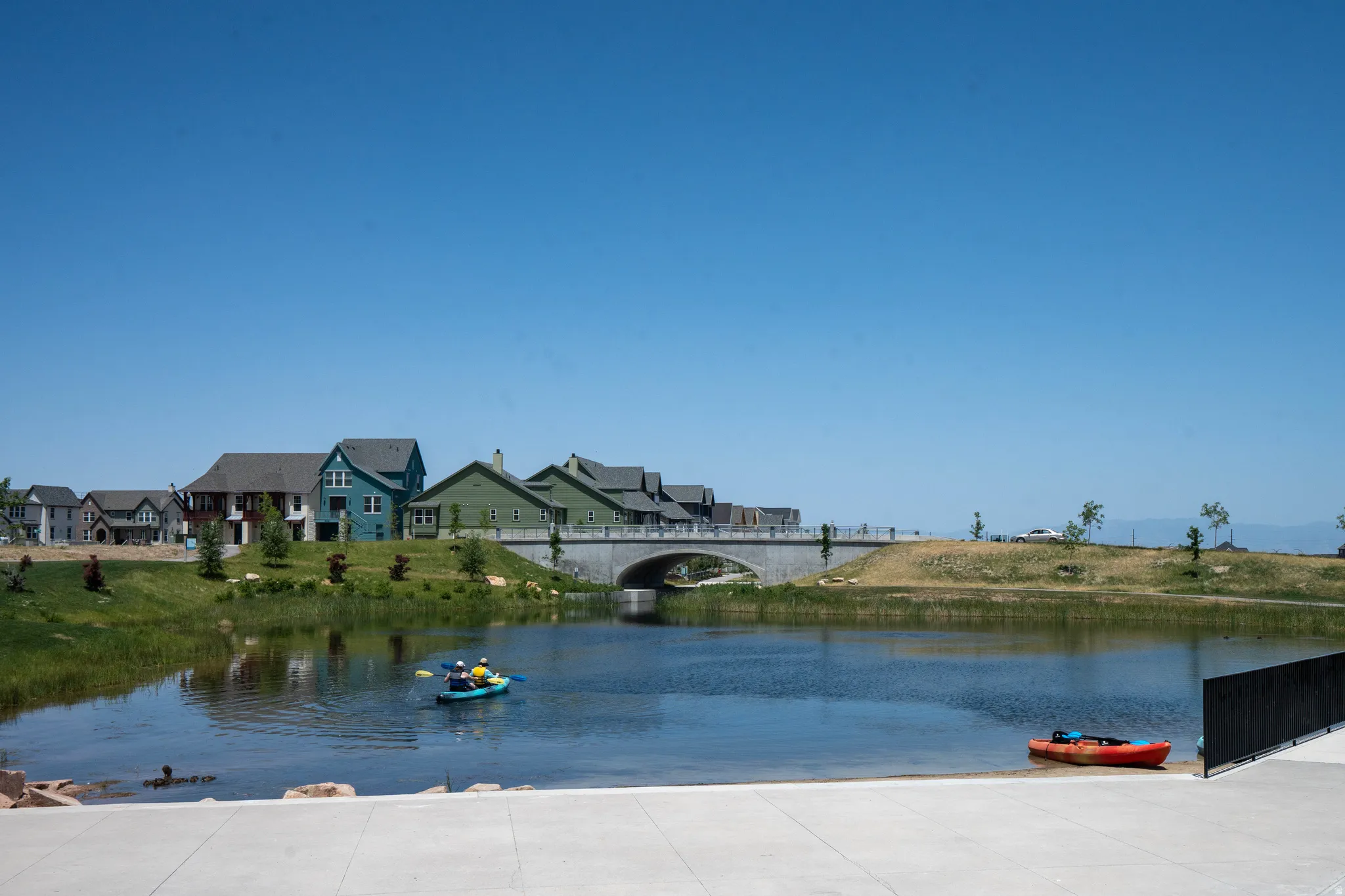 Waterfront homes featuring various exterior finishes, a stone bridge, and a navigable body of water