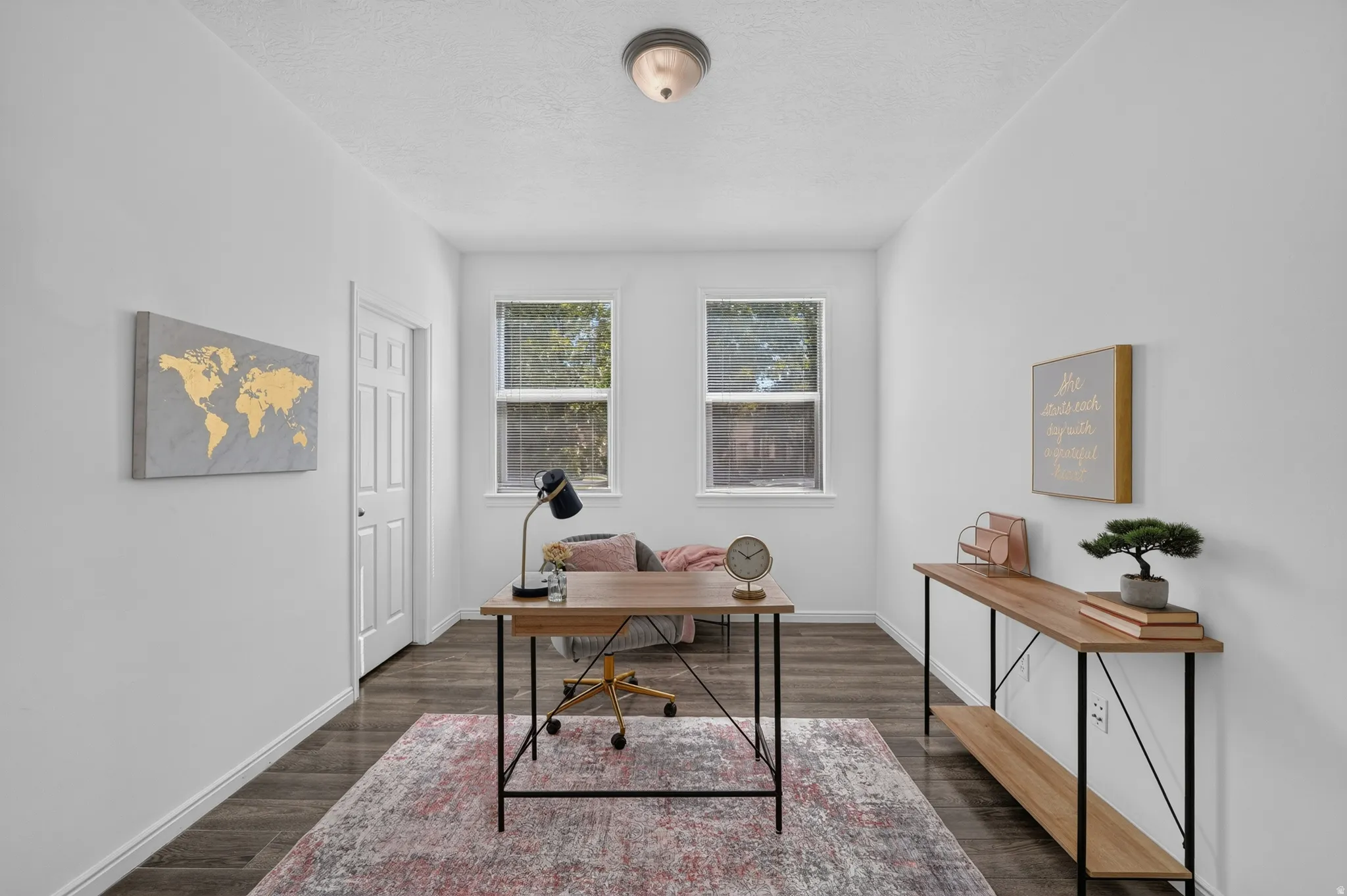 Room with two windows, wood-finish flooring, white walls, and a ceiling-mounted light fixture