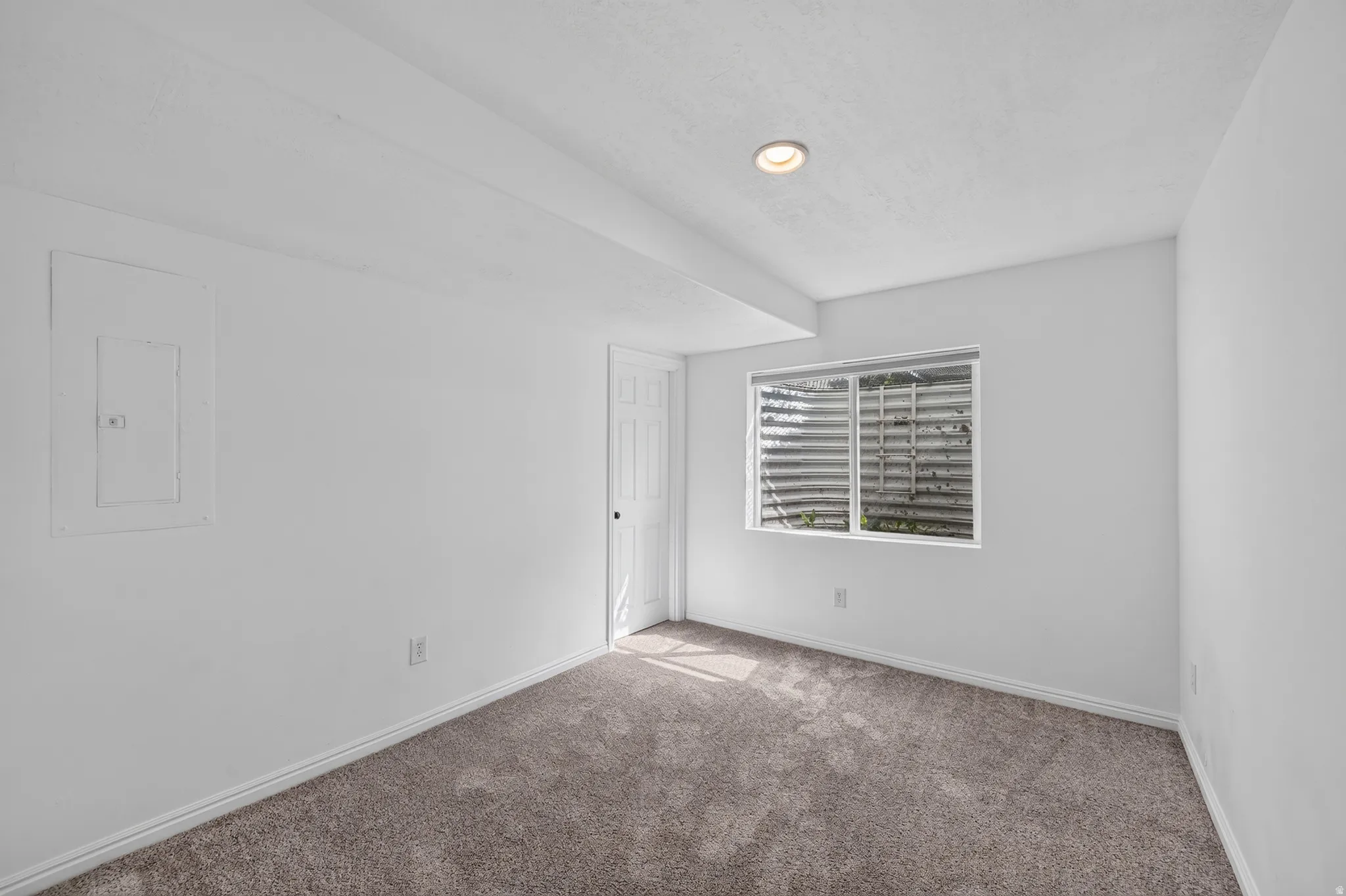 Interior room featuring neutral wall finishes, recessed ceiling lighting, a single window, and plush carpet flooring