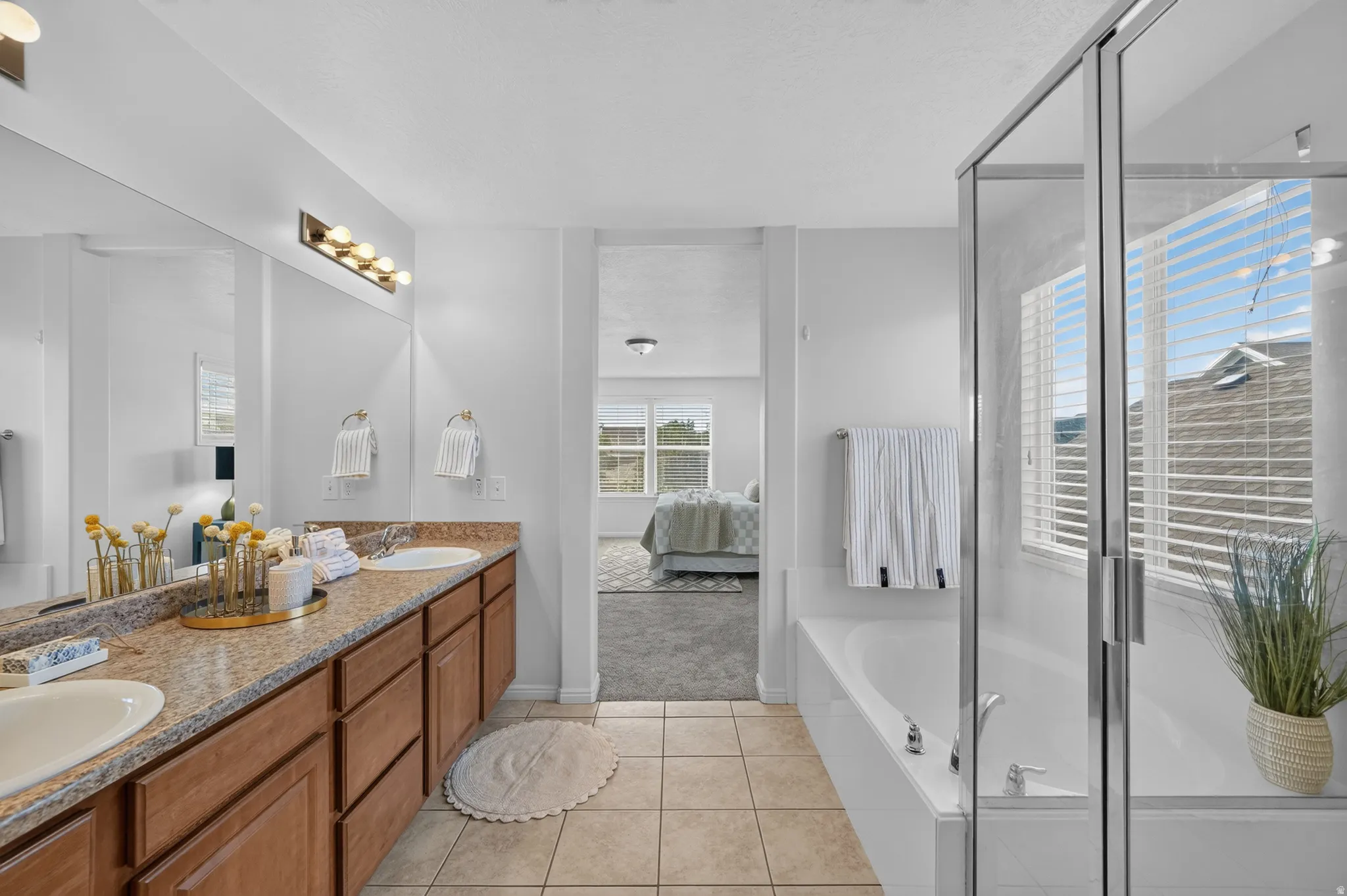 Bathroom featuring a double vanity with wood cabinetry and a speckled countertop