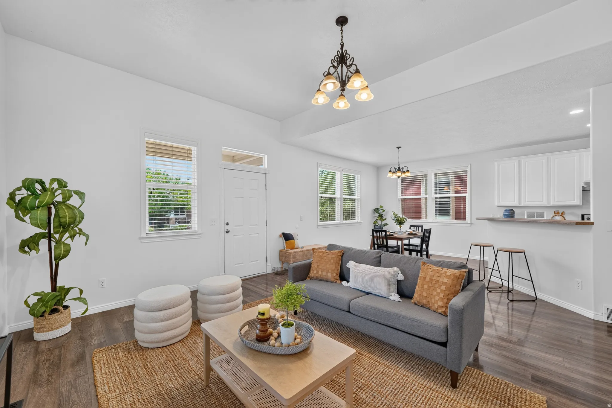Open concept living area featuring dark wood-finish flooring, white walls, and a recessed ceiling