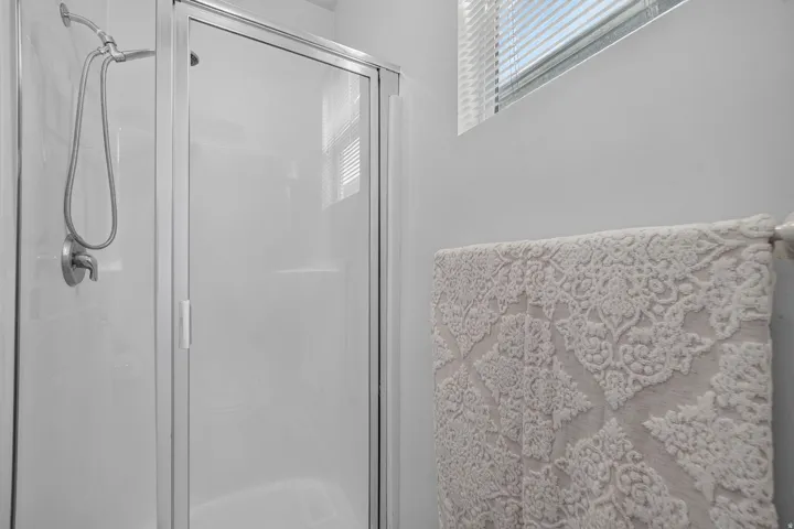 Shower enclosure with an aluminum frame and clear glass door