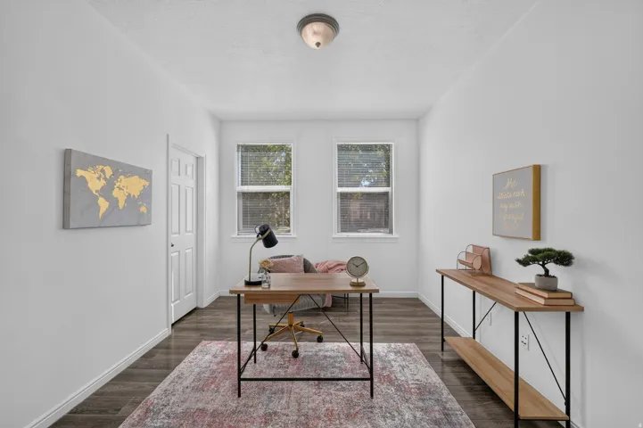 Room with two windows, wood-finish flooring, white walls, and a ceiling-mounted light fixture
