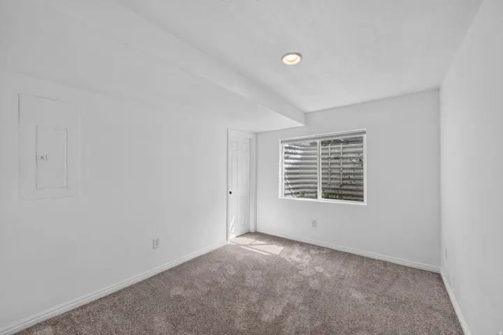 Interior room featuring neutral wall finishes, recessed ceiling lighting, a single window, and plush carpet flooring