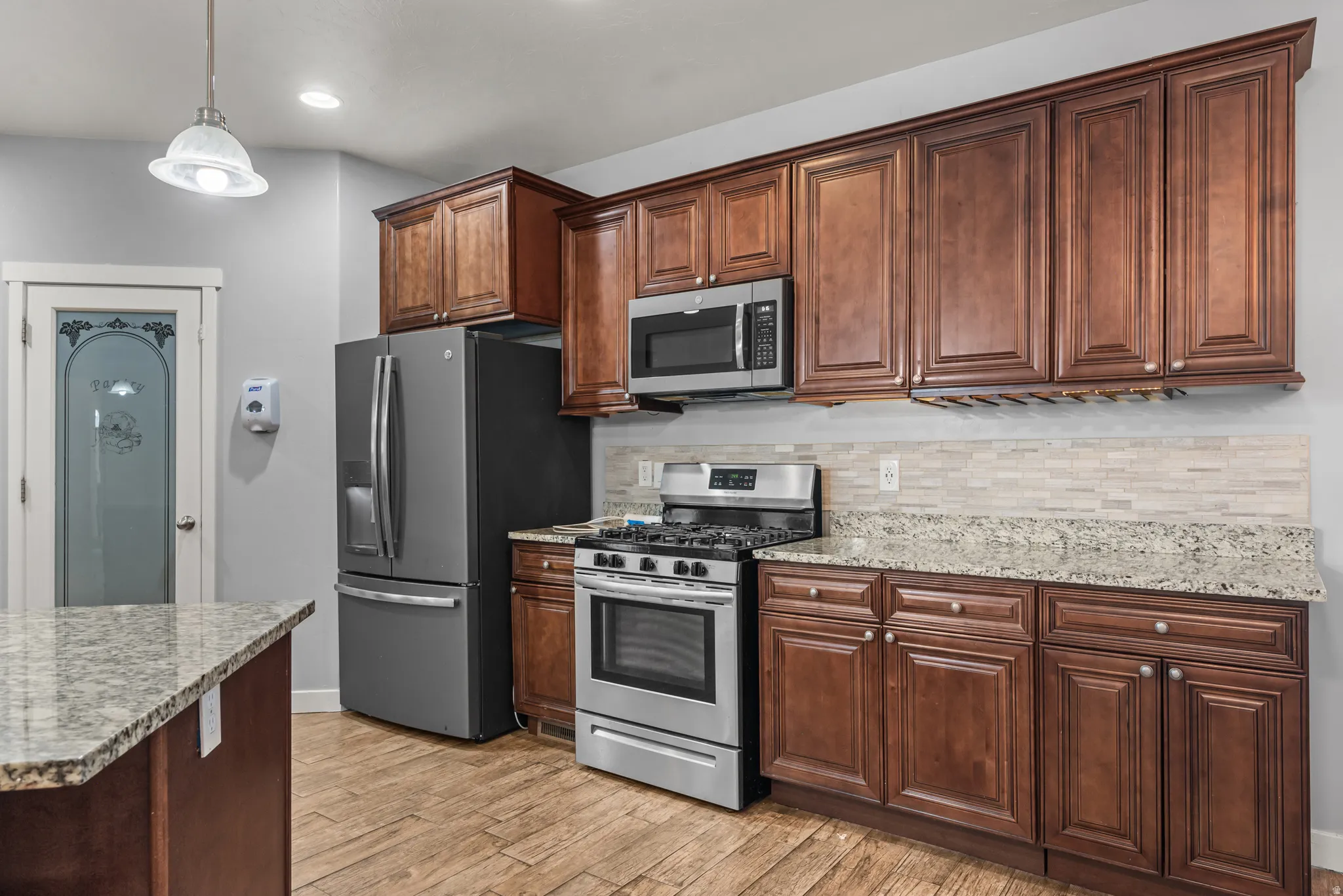 Kitchen featuring wood-finish cabinetry, granite countertops, and stainless steel appliances