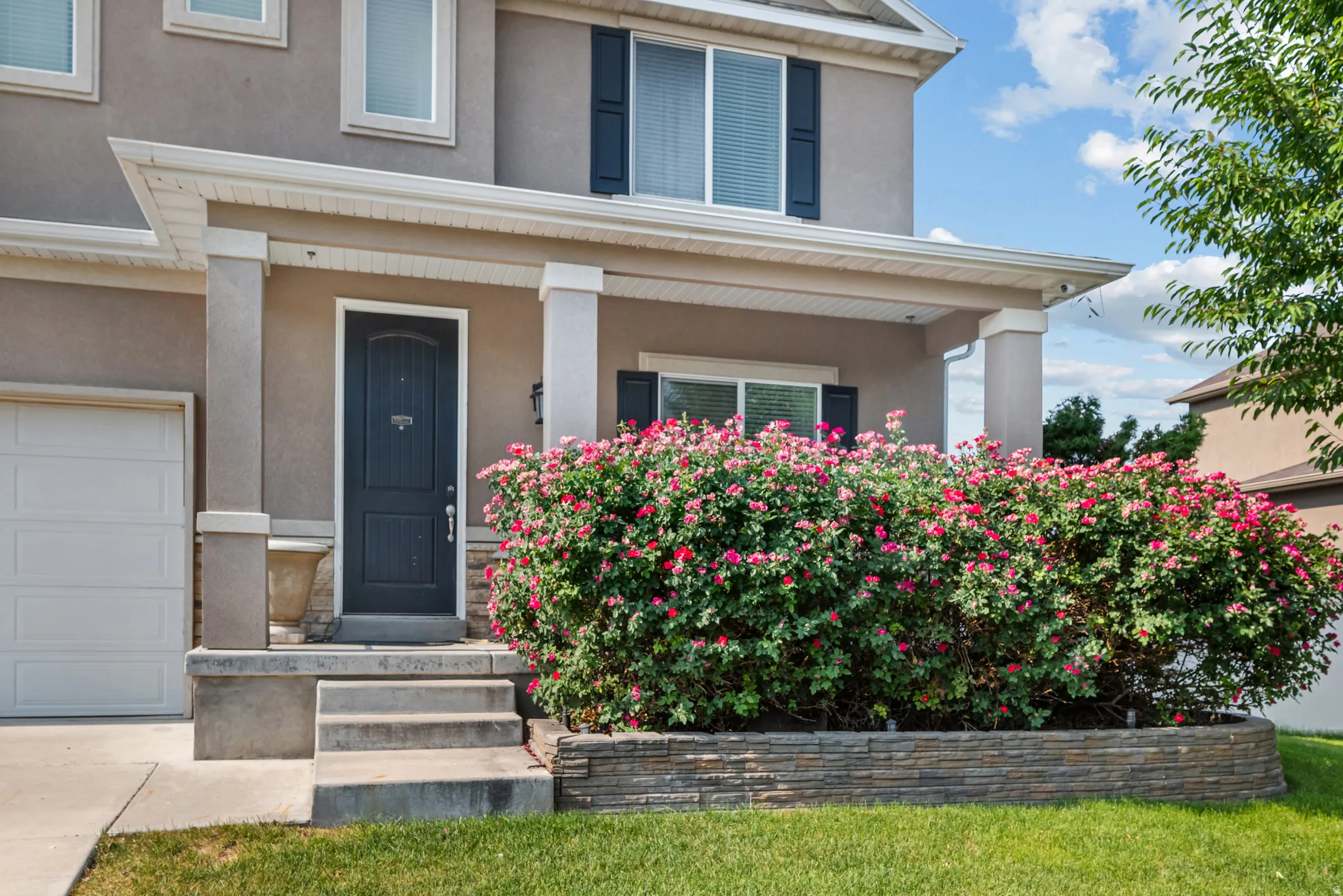 Exterior stucco finish with a covered porch entry