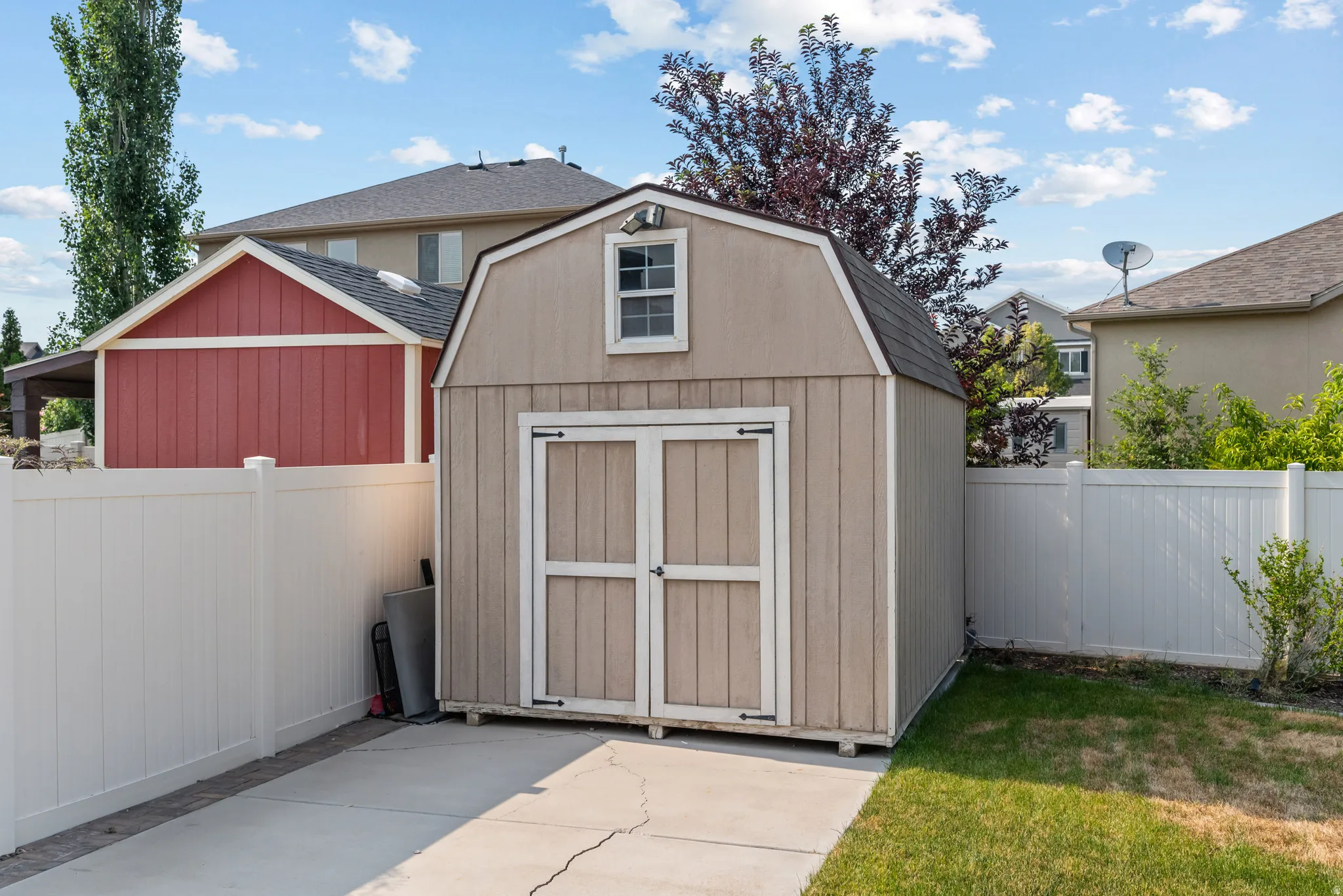 Freestanding shed featuring a gambrel roof and a single window