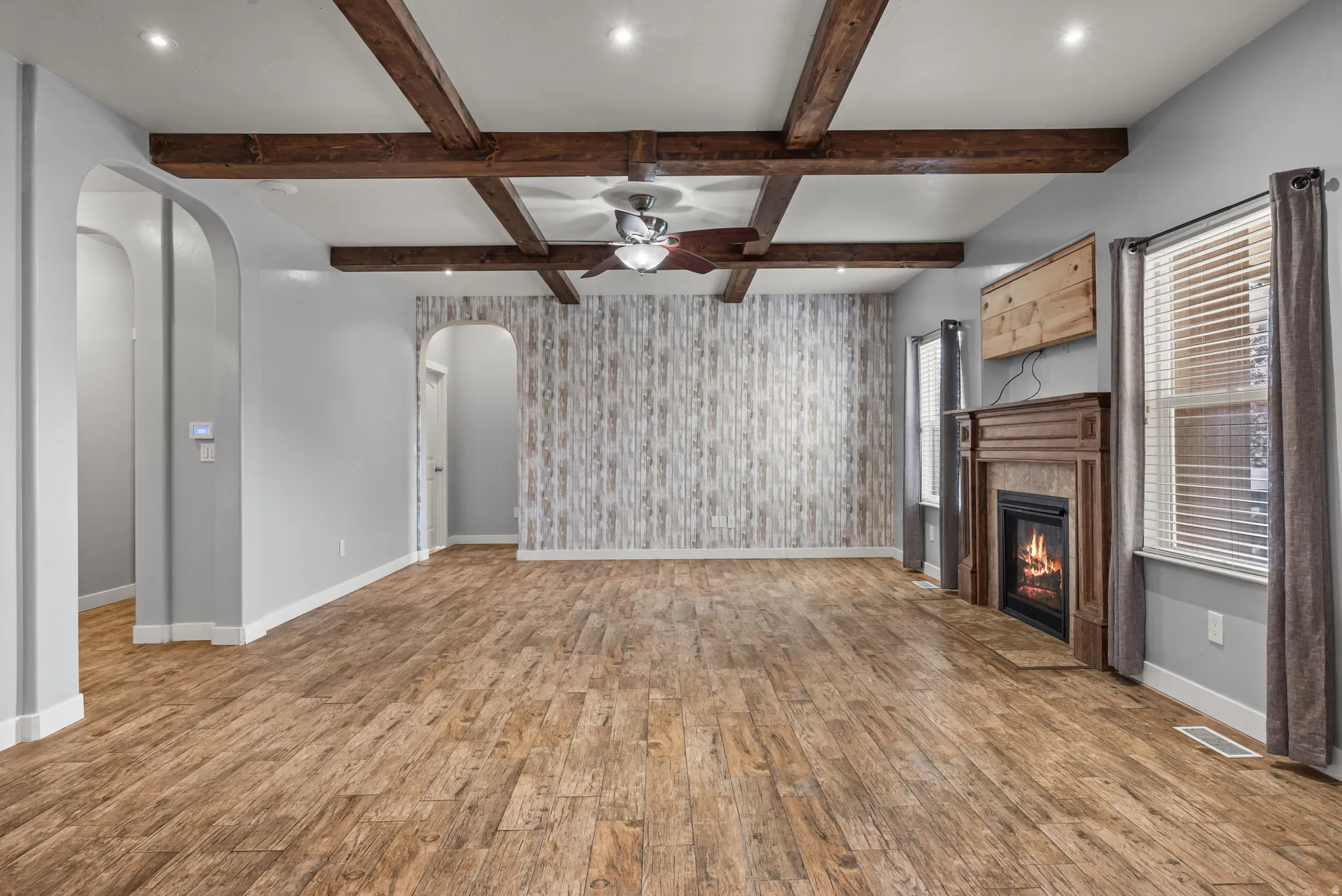 Spacious interior featuring wood-finish flooring, exposed wood ceiling beams, and recessed lighting
