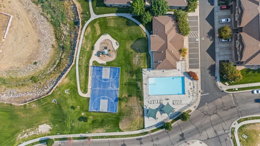 Community amenities featuring a swimming pool, basketball court, and playground surrounded by green spaces and paved pathways