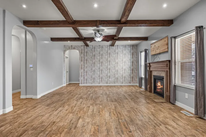 Spacious interior featuring wood-finish flooring, exposed wood ceiling beams, and recessed lighting